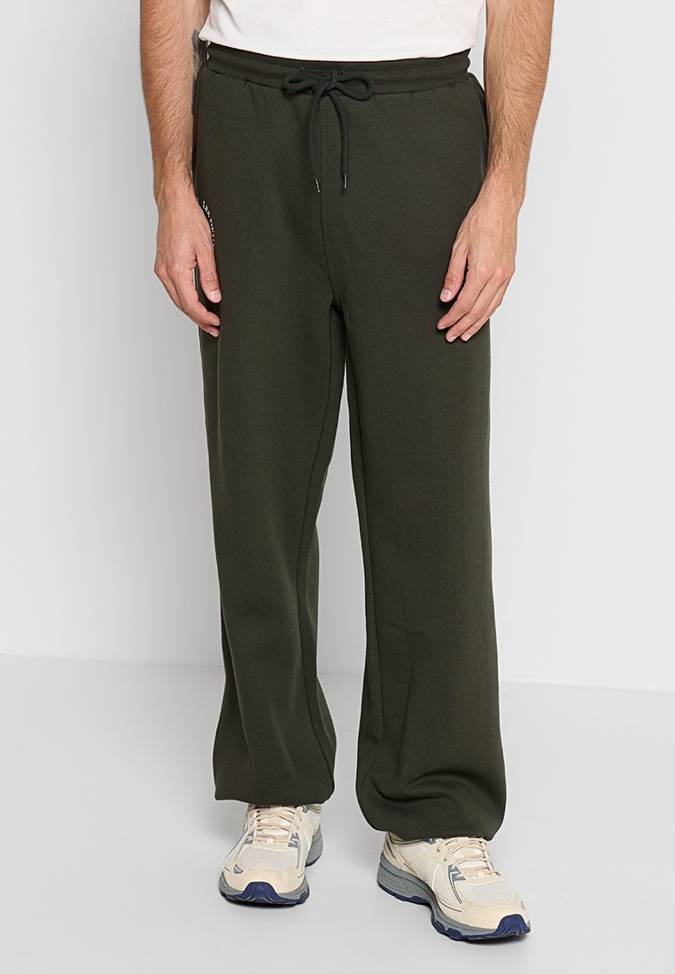 Olivgrüne Sweatpants mit einem Kordelzugbund und seitlichen Taschen. Hergestellt aus weichem Stoff, mit einem entspannten, geraden Beinschnitt.