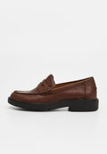 Herren-Braunlederloafer mit schwarzer Gummisohle und Steppnähten, seitlich auf einem schlichten, hellen Hintergrund gezeigt.