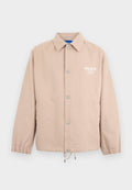 Beige Jacke mit Knöpfen, Kragen, elastischen Bündchen, Kordelzug am Saum und weißem "HUGO"-Logo auf der linken Brust.