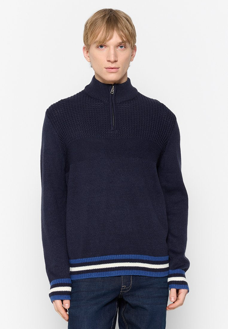Marineblauer Strickpullover mit hohem Kragen und halbem Reißverschluss. Verfügt über einen strukturierten Oberteil, gerippte Bündchen und einen gestreiften Saum in Blau und Weiß.