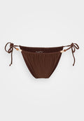 Brauner Bikiniunterteil mit verstellbaren Seitenschnüren, gerafftem Stoff und Akzenten aus Holzperlen. Sanfte Textur, minimalistische Design mit geringer Bedeckung.
