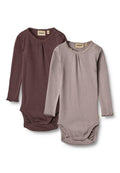 Zwei Langarmbodysuits in dunklem Mauve und hellem Taupe, mit Rüschendetails und Knopfverschluss am Hals. Hergestellt aus weichem Rippstoff.