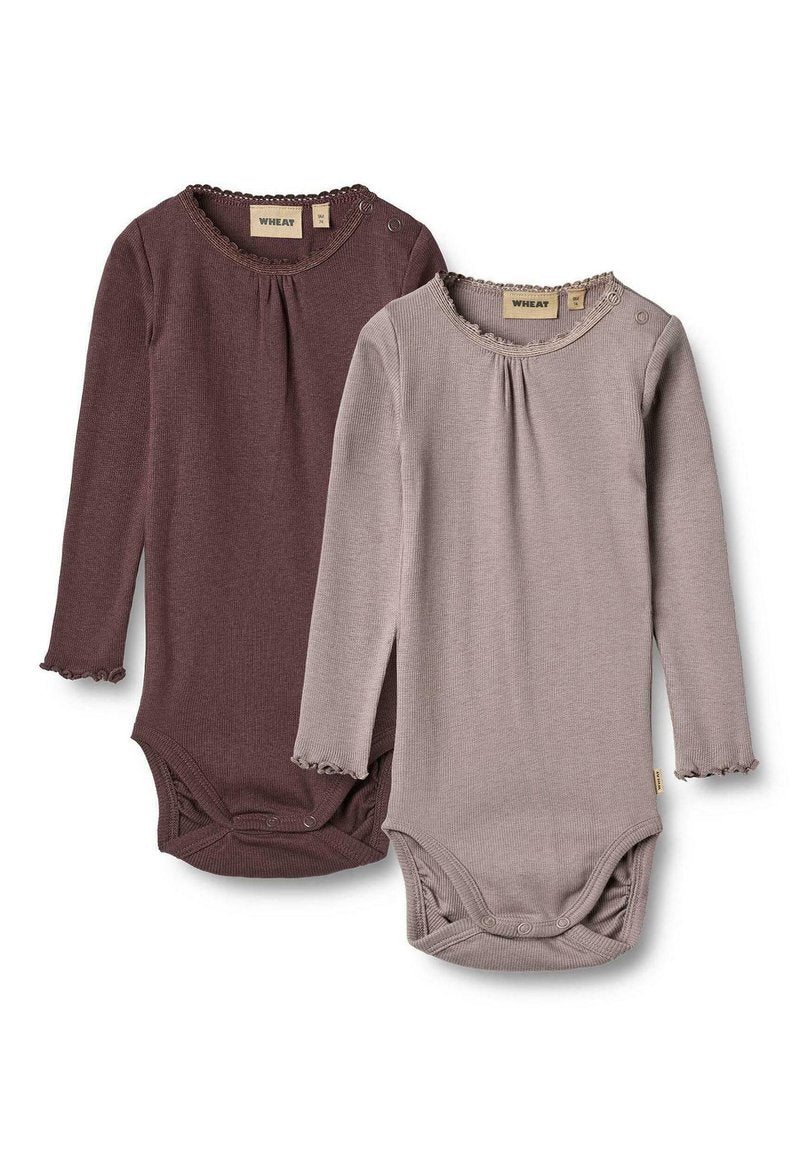Zwei Langarmbodysuits in dunklem Mauve und hellem Taupe, mit Rüschendetails und Knopfverschluss am Hals. Hergestellt aus weichem Rippstoff.