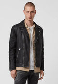 Schwarze Leder-Bikerjacke mit asymmetrischem Reißverschluss, Reverskragen und silbernen Beschlägen. Tragen über einem beigen Button-up-Hemd.