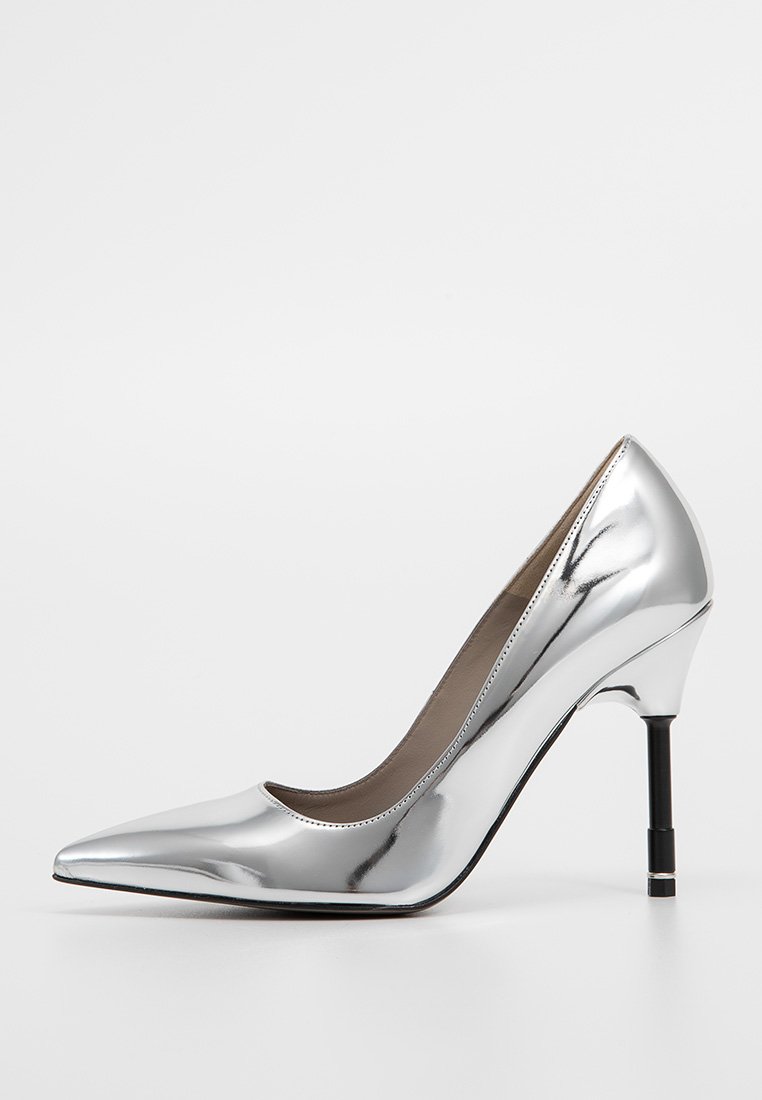 Silberne metallische High Heels, spitz zulaufendes Design, glatte Oberfläche, schlanker Absatz mit Blockakzent. Innen mit einem neutralen Material ausgekleidet.