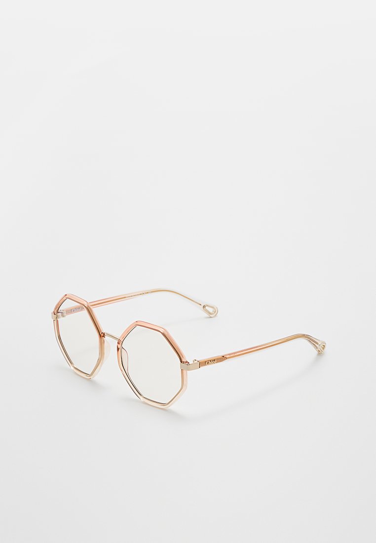 Achtkantige Sonnenbrille mit einem durchsichtigen, hellrosa Rahmen und goldenen Akzenten. Ausgestattet mit klaren Gläsern und schlanken goldenen Bügeln.