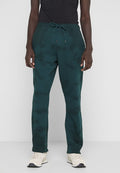 Grüne Tie-Dye-Sweatpants mit einem Kordelzugbund, die eine lockere Passform und eine weiche Textur aufweisen, kombiniert mit hellen Sneakers.