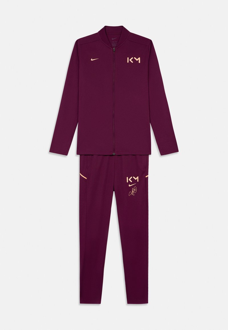 Maroon Trainingsanzug mit Reißverschlussjacke und passender Hose. Verziert mit goldenen Logos, K und Unterschrift-Detail. Glattes Material mit taillierter Passform.