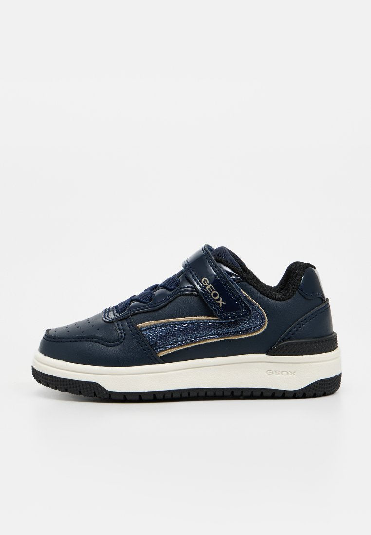 Marineblauer Kindersneaker mit Klettverschluss, strukturiertem Seitendetail, gepolsterter Sohle und schwarzer profilierter Außensohle.