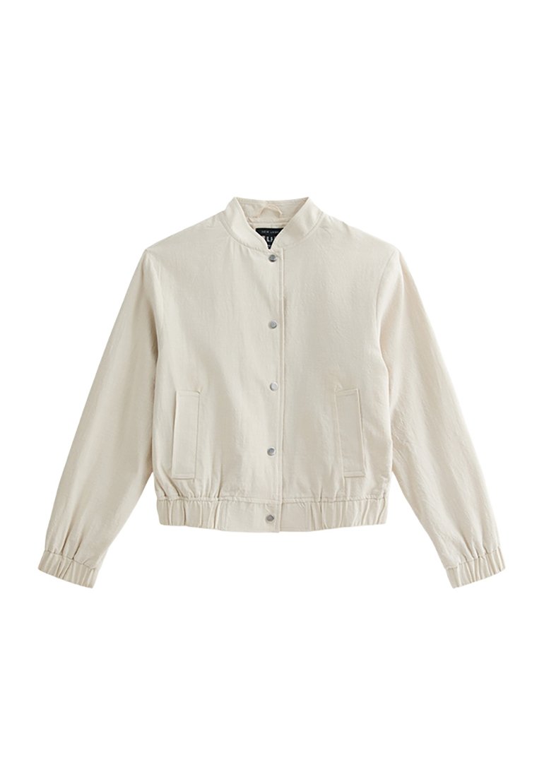 Hellbeige Bomberjacke mit Rundkragen, Druckknöpfen, seitlichen Taschen und elastischen Bündchen; aus einem glatten, strukturierten Stoff gefertigt.