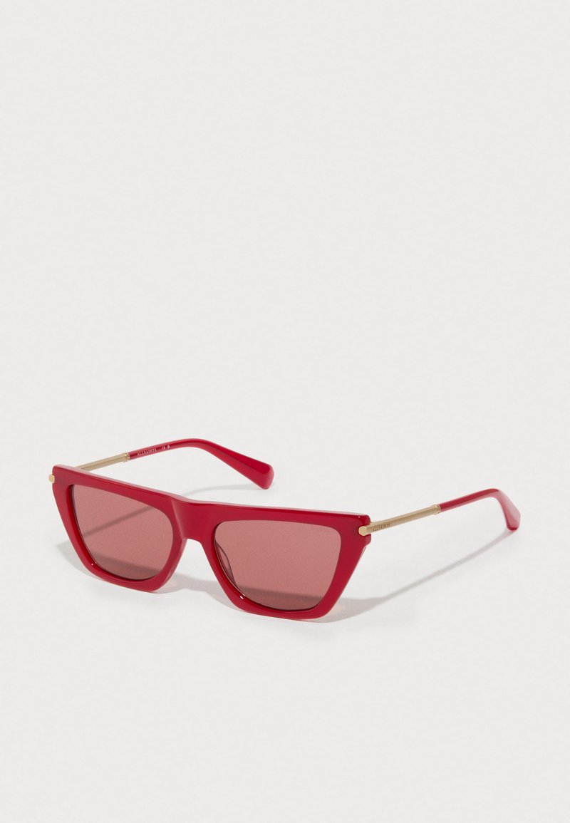 Rote rechteckige Sonnenbrille mit goldenen Metallbügeln und passenden rot getönten Gläsern auf einem weißen Hintergrund.