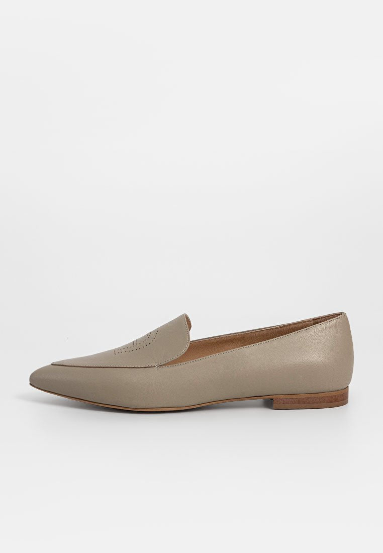 Beige Lederloafer mit spitzem Zehenbereich, dezenten Durchbrüchen auf dem Obermaterial und einem niedrigen Holzabsatz. Glatte Textur und minimalistisches Design.