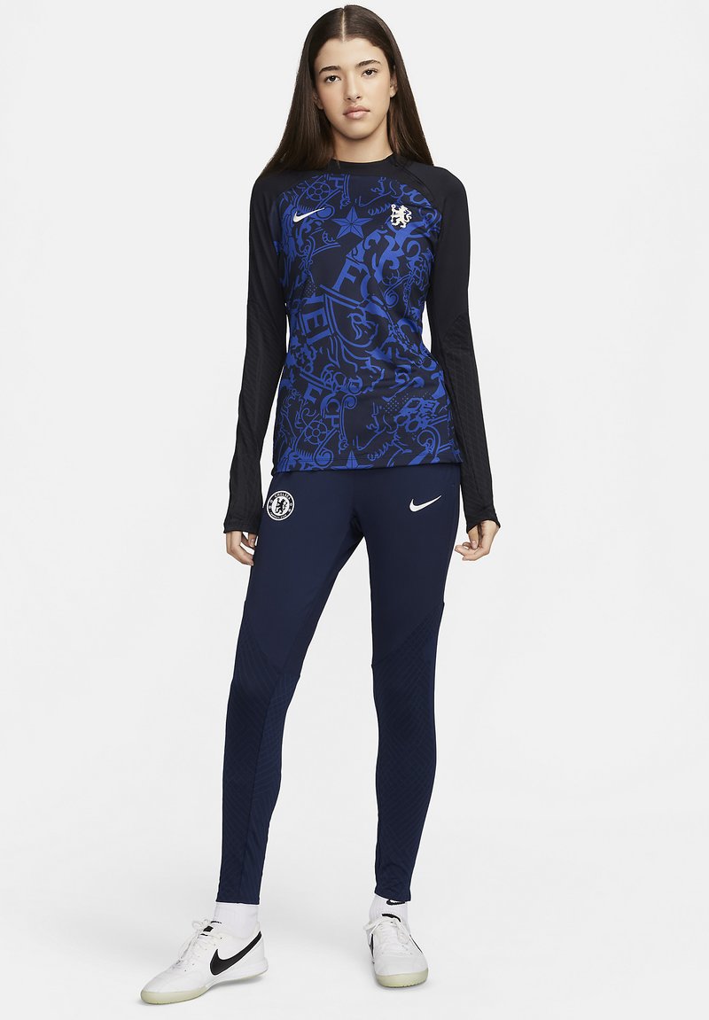 Nike Langarmshirt und enganliegende Hose in Dunkelblau mit grafischen Mustern. Das Shirt hat einen Rundhalsausschnitt und ein Logo; die Hose hat strukturierte Akzente.