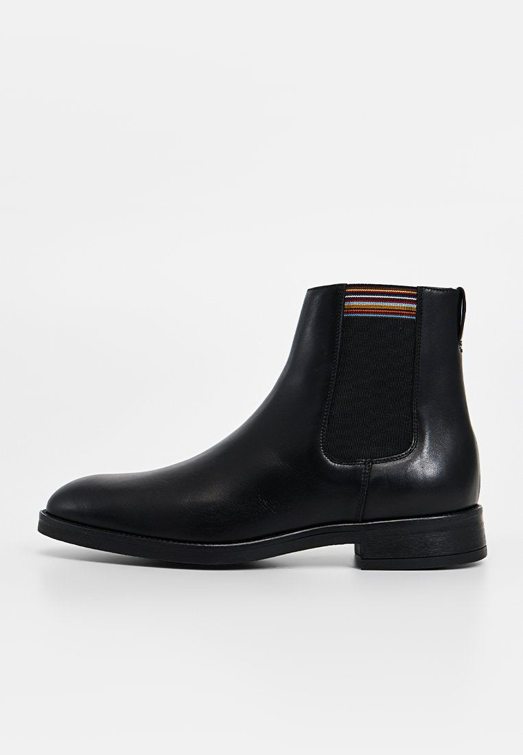 Schwarzer Chelsea-Stiefel aus Leder mit elastischen Seitenteilen, die mehrfarbige Streifen aufweisen, runder Zehenpartie und niedrigem Blockabsatz. Glatte Textur.
