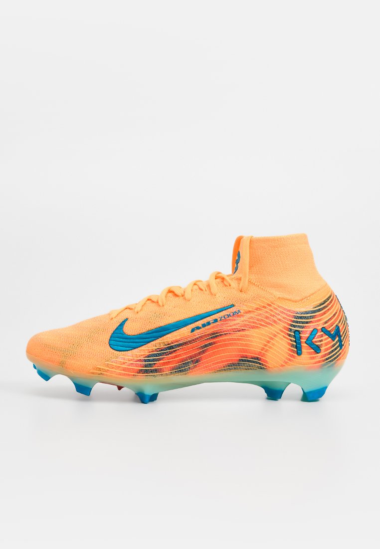 Leuchtend orangefarbener Fußballschuh mit strukturiertem Mesh-Obermaterial, blauen Akzenten, mittelhohem Schnitt und transparenter Sohle mit konischen Stollen.