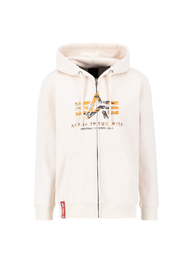 Cremefarbener Kapuzenpullover mit einem Reißverschluss auf der Vorderseite, der ein Camouflage-Muster und auffällige Schriftzüge zeigt. Mit Kapuze und seitlichen Taschen ausgestattet. Rote Akzente am Saum.