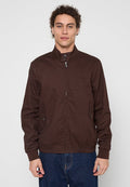 Braune, leichte Jacke mit hohem Kragen, Reißverschluss und geknöpften Seitentaschen. Verfügt über eine glatte Textur und einen elastischen Saum.