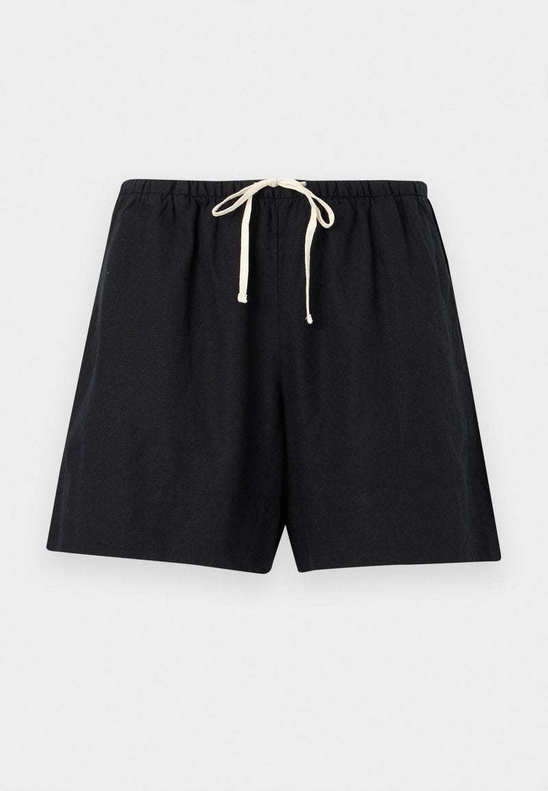 Schwarze legere Shorts mit elastischem Bund und weißem Kordelzug, flach auf einem hellgrauen Hintergrund ausgelegt.