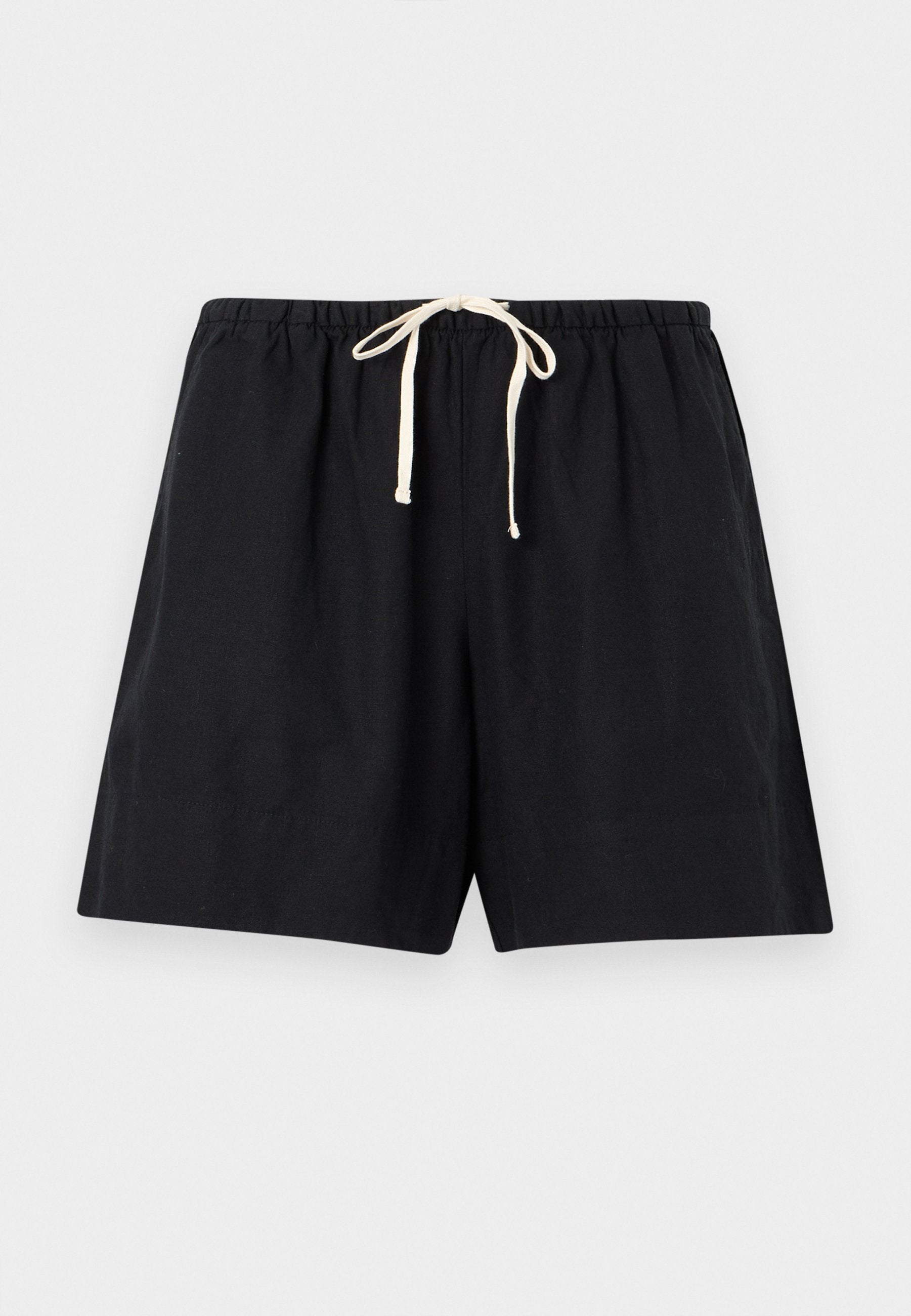 Schwarze legere Shorts mit elastischem Bund und weißem Kordelzug, flach auf einem hellgrauen Hintergrund ausgelegt.