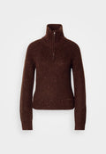 Brauner Strickpullover mit hohem Kragen und halbem Reißverschluss. Strukturiertes Muster mit roten und weißen Sprenkeln. Figurbetonte Silhouette.