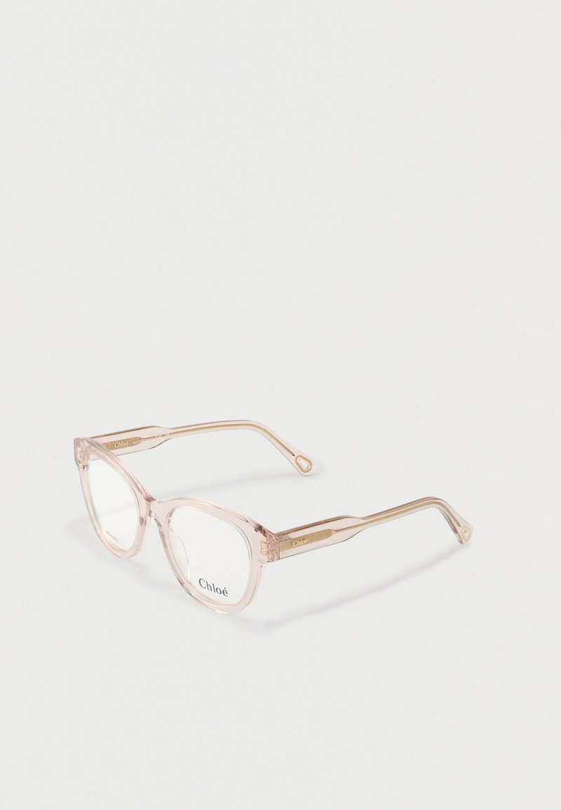 Transparente hellrosa rechteckige Brille mit klaren Gläsern und dezenten goldenen Akzenten an den Bügeln vor weißem Hintergrund.