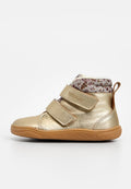 Goldener, metallischer Baby-Stiefel mit floral gemustertem Stoff am Kragen, zwei verstellbaren Klettverschlüssen und einer Gummisohle. Glatte Textur.