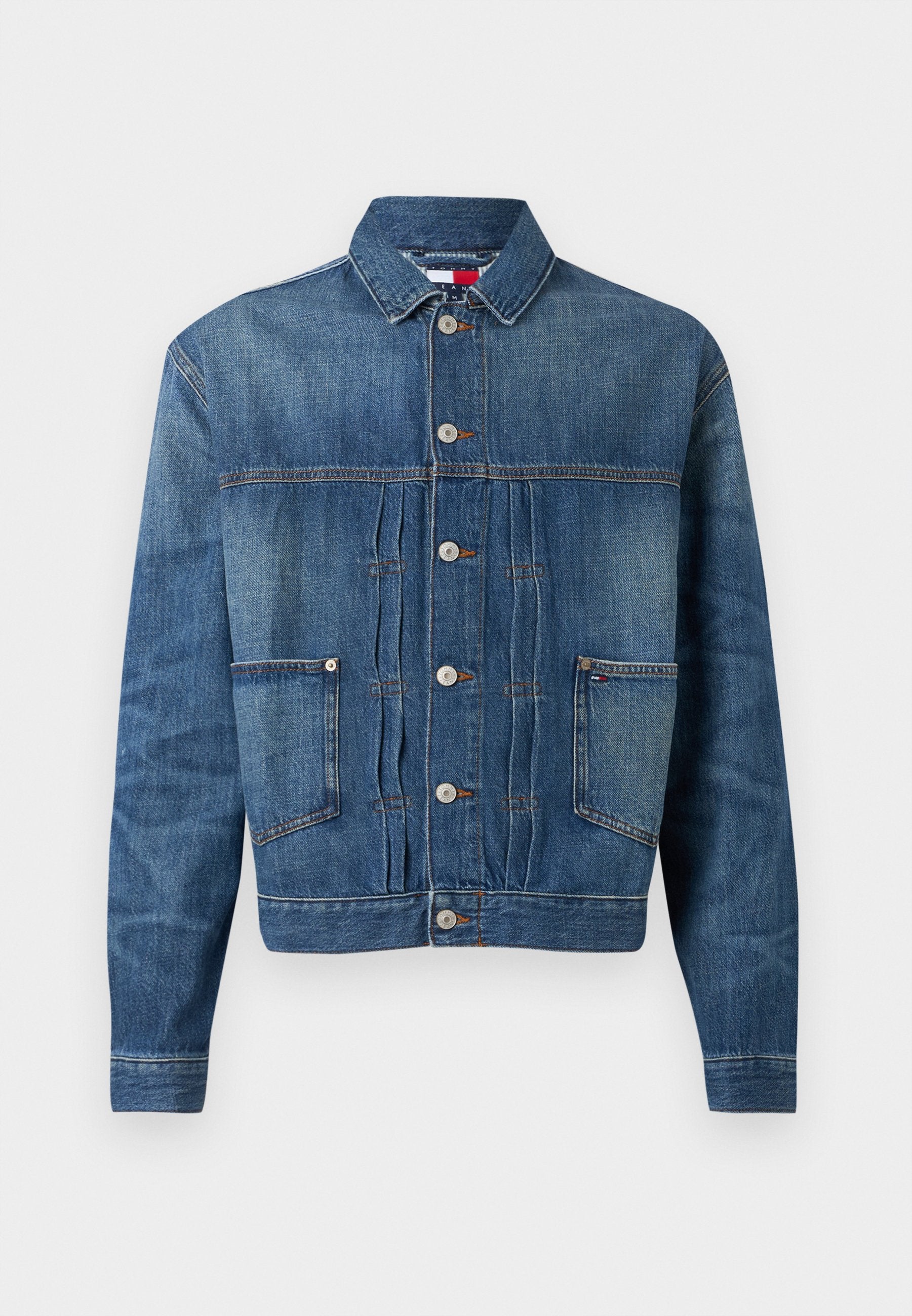 Dunkelblaue Jeansjacke mit Druckknopfverschluss, zwei Brusttaschen und subtiler Ausbleichung. Gerade geschnitten mit klassischem Kragen.