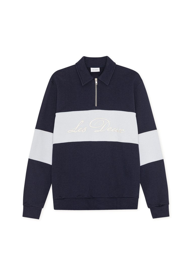 Marineblauer Pullover mit einem weißen horizontalen Streifen und Reißverschlusskragen. "Les Deux" in Creme auf dem Streifen gestickt. Weicher Stoff, klassischer Schnitt.