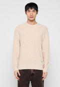 Beiger Strickpullover mit Rundhalsausschnitt, gerippten Bündchen und Saum. Verfügt über ein kleines Logotag in der Nähe des Saums. Das Material wirkt weich und strukturiert.