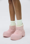 Rosa Gummistiefel mit strukturiertem, flauschigem Obermaterial, weicher Innensohle und kräftiger Sohle. Getragen mit hellgrünen, flauschigen Kniestrümpfen.