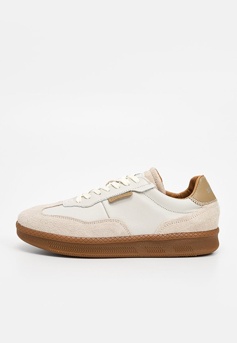 Sneaker mit beiger Wildlederzehe, weißen Lederseiten und brauner Gummisohle mit strukturiertem Muster. Die Schnürsenkel sind cremefarben.