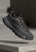 Schwarzer Trail-Laufschuh mit strukturiertem Obermaterial, Schnürsystem und dicker Gummisohle. Verfügt über "DRYVENT"-Markierung an der Seite.