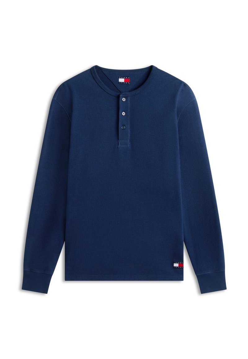 Dunkelblaues Henley-Shirt mit langen Ärmeln, drei Knöpfen, gerippten Bündchen und kleinen Tommy Jeans Logo-Patches am Hals und Saum.