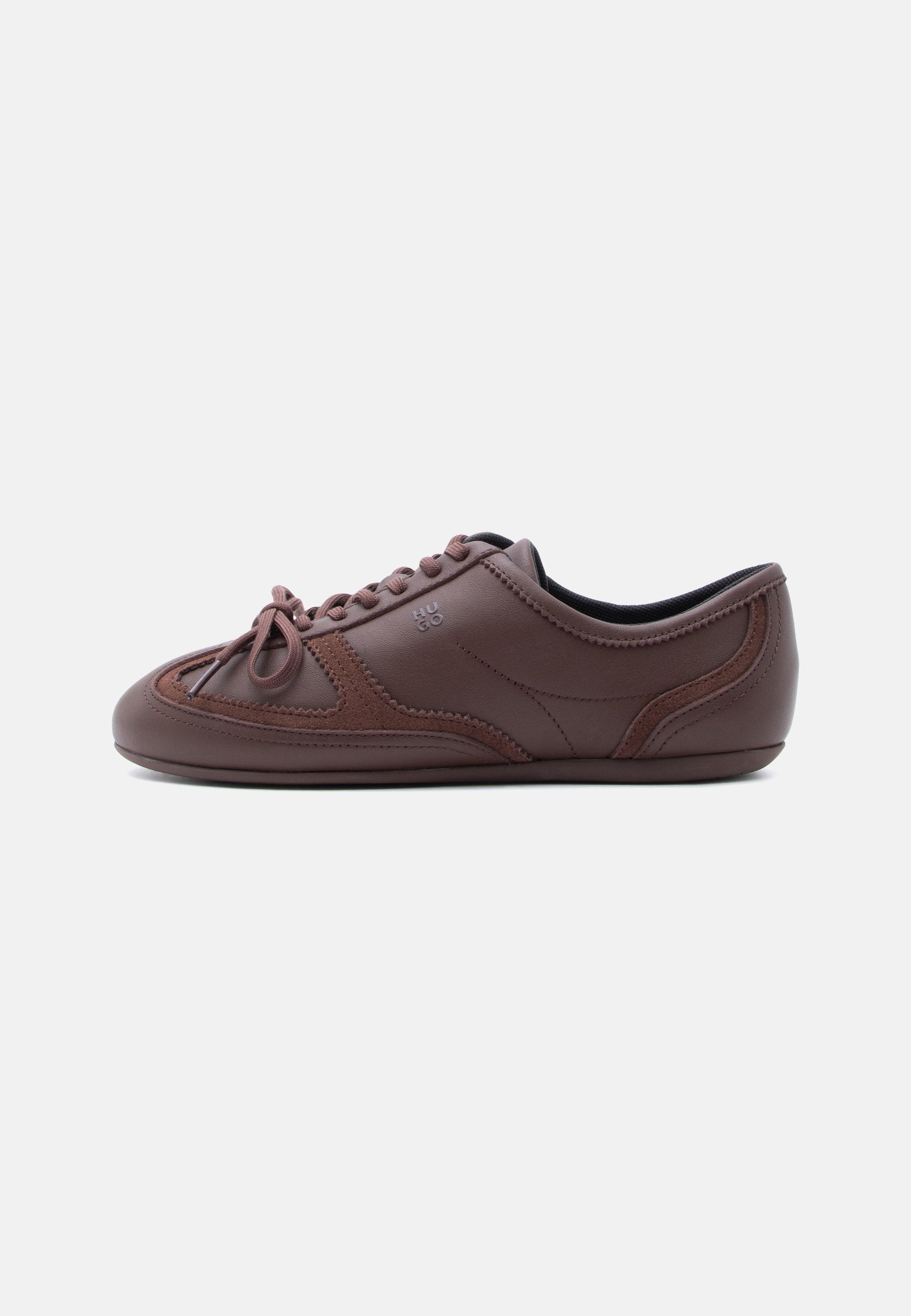 Brauner Sneaker mit niedrigem Schaft und Schnürsenkeln, mit gesteppter Wildleder-Details und "HUGO"-Logo an der Seite, seitlich auf weißem Hintergrund abgebildet.