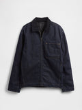 Dunkelblaue Jeansjacke mit Reißverschluss vorne, Cordkragen, langen Ärmeln und einer großen quadratischen Brusttasche vor weißem Hintergrund.