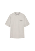 Graues Kurzarm-T-Shirt aus Baumwolle. Mit Rundhalsausschnitt und einem kleinen, dunkelgrauen Logo auf der Brust. Lockere Passform.