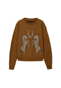 Das braune Sweatshirt verfügt über einen gerundeten Ausschnitt und überschnittene Schultern, mit einem Design aus zwei silbernen Pferden und einem Hufeisen auf der Vorderseite.
