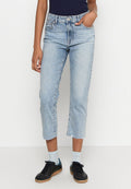 Hellblaue cropped Jeans aus Denim mit rohem Saum, ausgestattet mit einem Fünf-Taschen-Design und einer natürlichen, ausgewaschenen Textur, kombiniert mit schwarzen Sneakern.