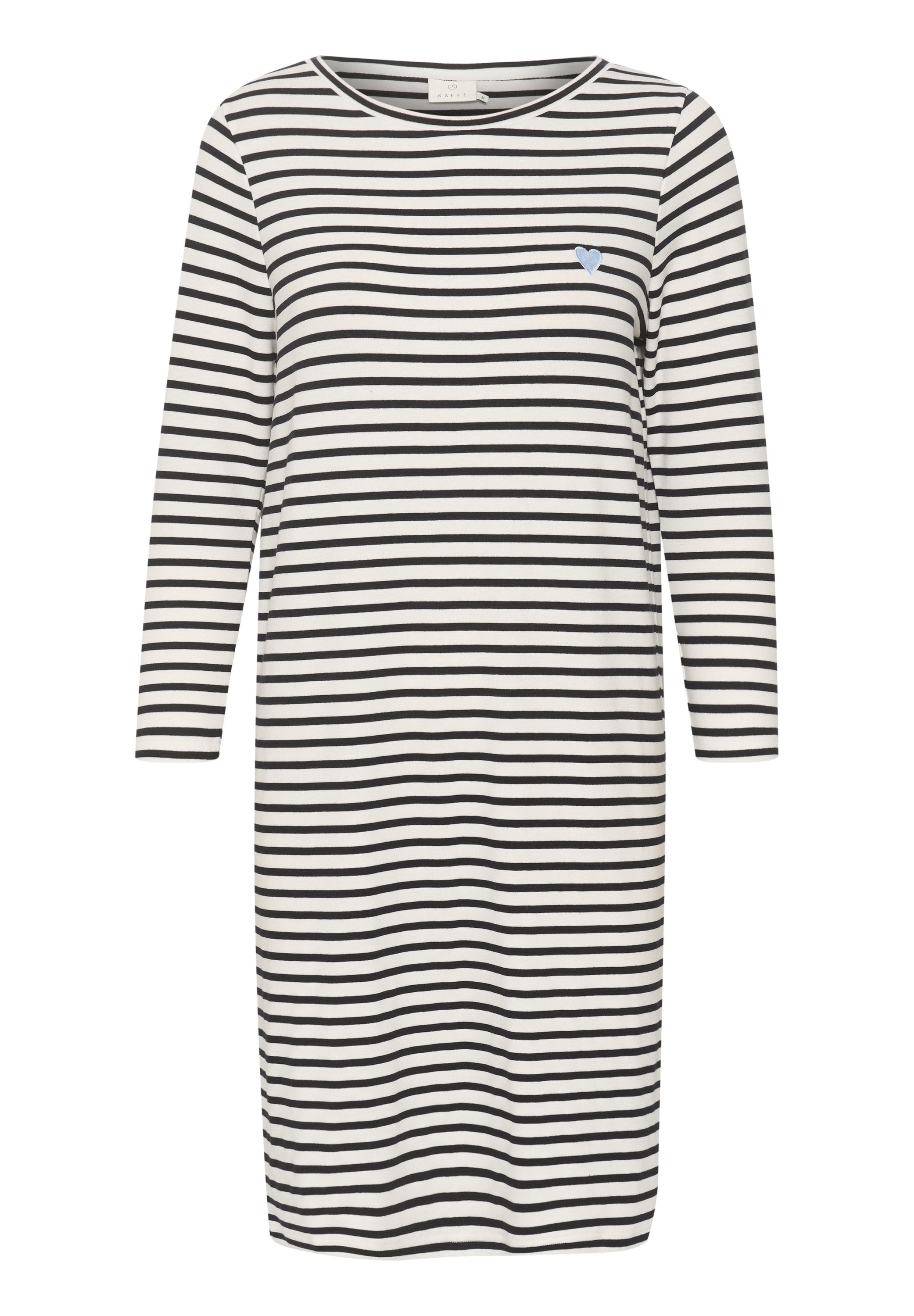 Langärmliges, knielanges weißes Kleid mit schwarzen horizontalen Streifen und einem kleinen blauen Herzsymbol auf der linken Brust.