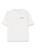 Weißes Baumwoll-T-Shirt mit lockerer Passform. Hat einen runden Halsausschnitt und kurze Ärmel. "Cozy Club" in hellgrau auf der linken Brust aufgedruckt.