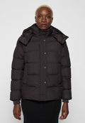 Schwarze Pufferjacke mit hohem Kragen, Knopfverschluss und seitlichen Taschen. Hergestellt aus einem wattierten, isolierenden Material mit einer glatten Oberfläche.