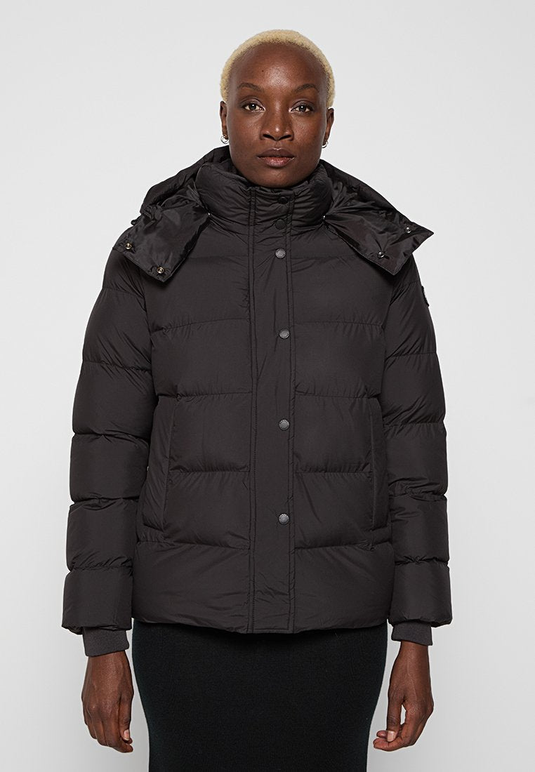 Schwarze Pufferjacke mit hohem Kragen, Knopfverschluss und seitlichen Taschen. Hergestellt aus einem wattierten, isolierenden Material mit einer glatten Oberfläche.