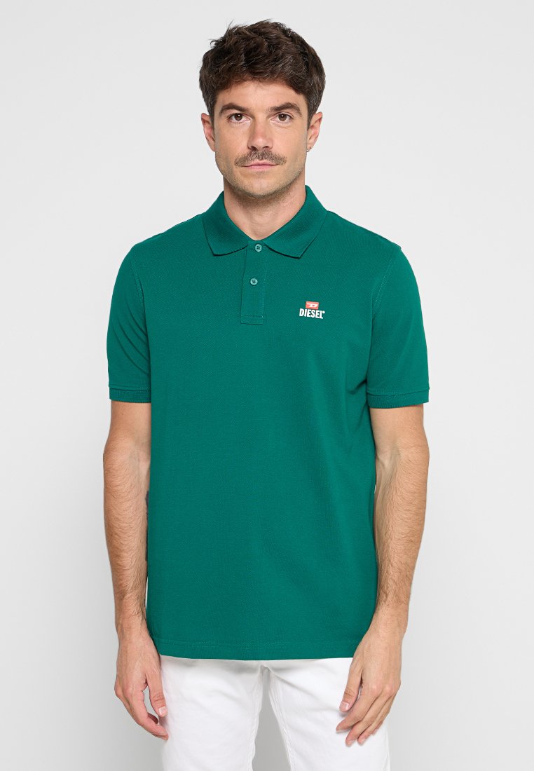 Grünes Poloshirt aus strukturiertem Stoff, mit klassischem Kragen, zweiknöpfiger Knopfleiste und kleinem roten und weißen Diesel-Logo auf der Brust.