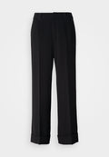 Schwarze, weit geschnittene Hosen mit maßgeschneidertem Design, die am Saum einen Aufschlag aufweisen und aus einem glatten Stoff gefertigt sind, um ein elegantes Erscheinungsbild zu verleihen.