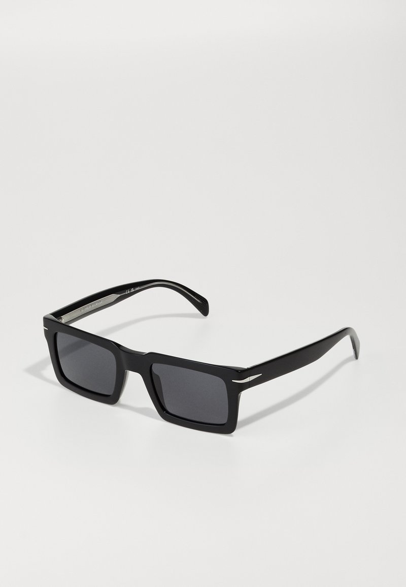 Schwarze rechteckige Sonnenbrille mit dunklen Gläsern, glänzendem Kunststoffrahmen und silbernen Akzenten an den Schläfen, ausgestattet mit einer strukturierten Oberfläche an den Bügeln.