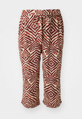 Rote und braune gemusterte Hosen mit einem elastischen Bund. Sie haben ein geometrisches Motiv auf einem hellen Hintergrund. Knöchellang und aus leichtem Stoff.