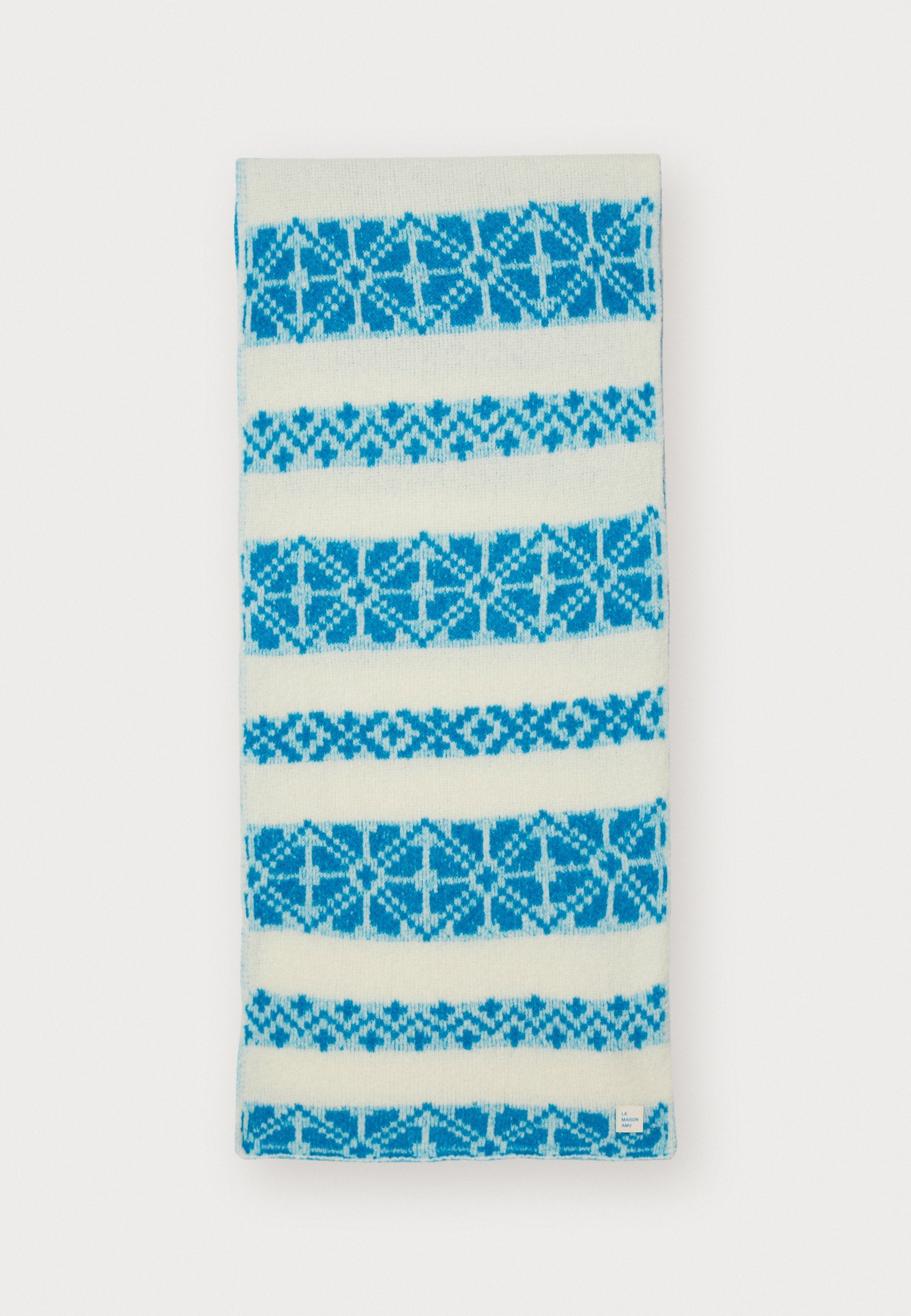 Strickschal in Creme mit abwechselnden breiten Streifen in Hell- und Dunkelblau, ausgestattet mit einem geometrischen Muster und einem kleinen Etikett am unteren Rand.