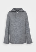 Grauer Strickpullover mit hohem Kragen, halbzipper vorne und glockenförmigen Ärmeln. Mit gerippten Bündchen und strukturierter Oberfläche.