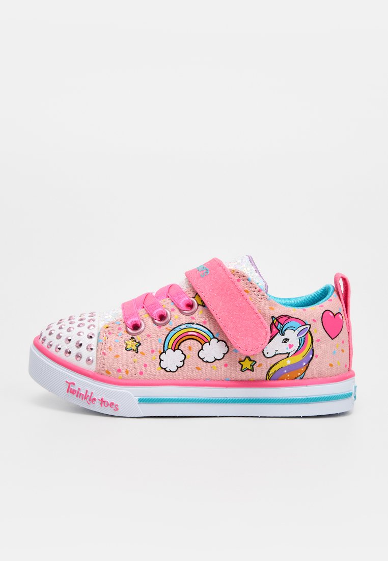 Pinkfarbener Kindersneaker mit Einhorn-, Regenbogen-, Stern- und Herzmustern, pinken Riemen, silbernen Stollen an der Spitze und dem Schriftzug "Twinkle Toes" auf der weißen Sohle.