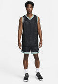 Schwarzes Basketballtrikot mit einem strukturierten Muster, ausgestattet mit einem grünen und weißen Saum, kombiniert mit passenden Shorts, alles von Nike.